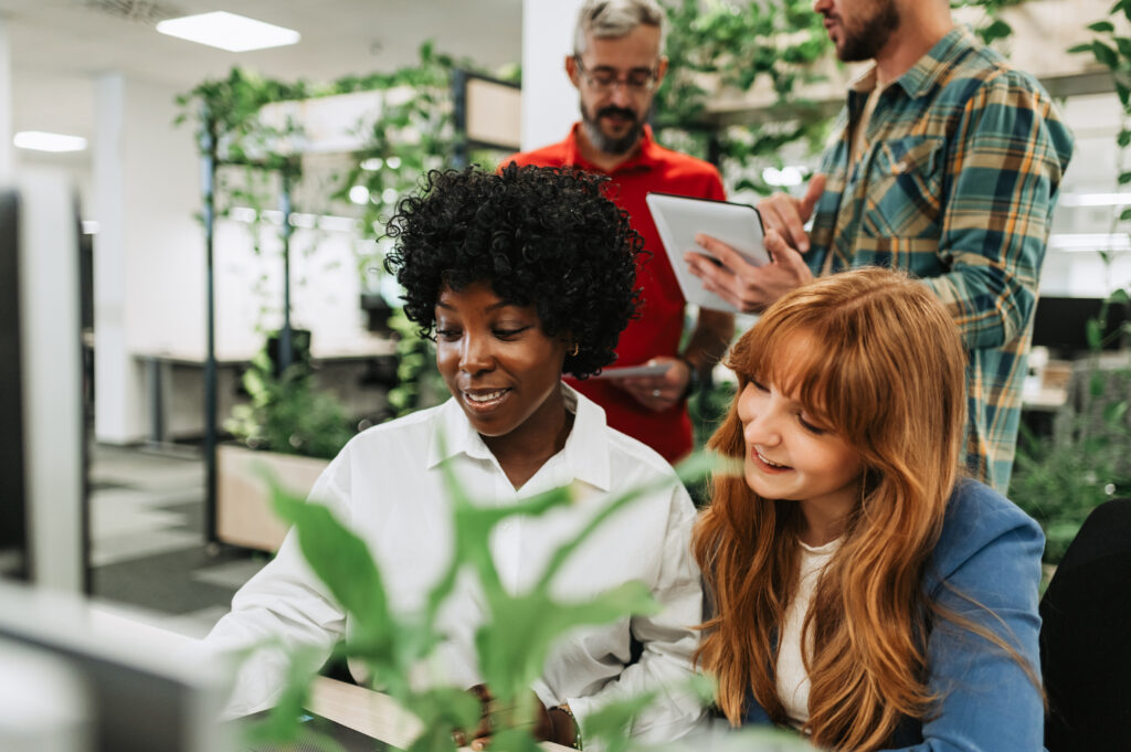 Portrait of multicultural colleagues working on a laptop at the office.